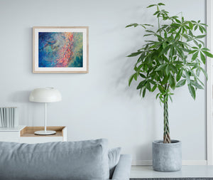 "Circling" art print displayed on wall of bright living room with large plant