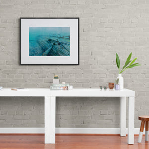 Lost to Time shipwreck print on wall of hallway with white table