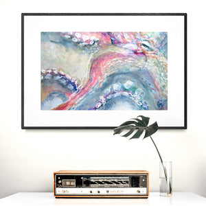 Retro clock radio on cabinet with framed print of colourful octopus
