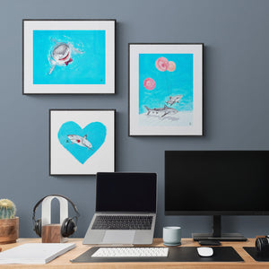 Grouping of three art prints of great white sharks in a home office with desk and laptop.