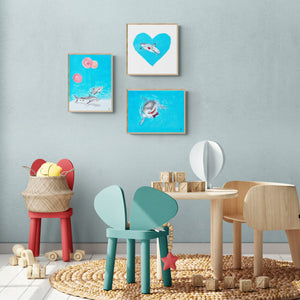 Grouping of three art prints of great white sharks in a kid's playroom.