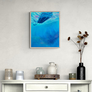 Painting of underwater scene above rustic cabinet with small jugs