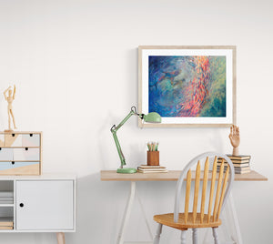 "Circling" art print displayed on wall of simple study room above desk and chair.